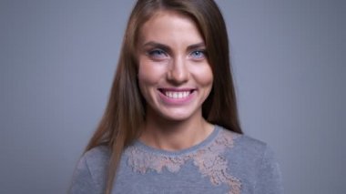 Baştan çıkarıcı genç beyaz kadın gülümseyen göz kırpıyor ve kameraya bakarak portre portre.