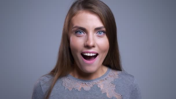 Close-up retrato de alegre jovem caucasiano feminino sendo surpreendido sorrindo e olhando para a câmera — Vídeo de Stock