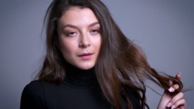 Onun saç poz ile oynayan ve kameraya gülümseyen çarpıcı oldukça beyaz kadın modeli closeup