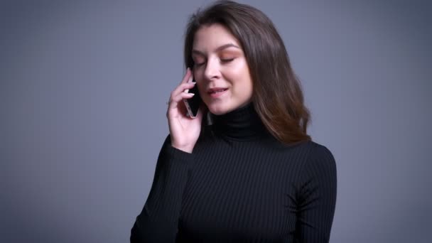 Primer plano retrato de atractiva mujer caucásica moderna casualmente hablando por teléfono y sonriendo — Vídeos de Stock