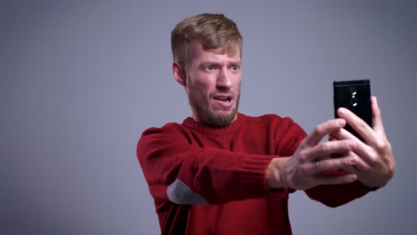 Closeup portret van een man van middelbare leeftijd Kaukasische nemen van selfies op de telefoon en gek rond het maken van verschillende gezichtsuitdrukkingen — Stockvideo