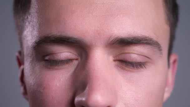 Retrato de close-up de belos olhos castanhos caucasianos masculinos olhando diretamente para a câmera com expressão confusa — Vídeo de Stock