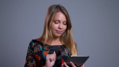 Closeup tablet üzerinde tarama ve yeşil ekran kamera gülümseyen için gösterilen genç neşeli beyaz kadın