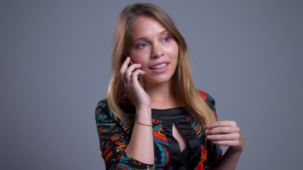 Close-up retrato de jovem alegre caucasiano feminino falando no telefone sorrindo rindo rindo e brincando com seu cabelo — Vídeo de Stock