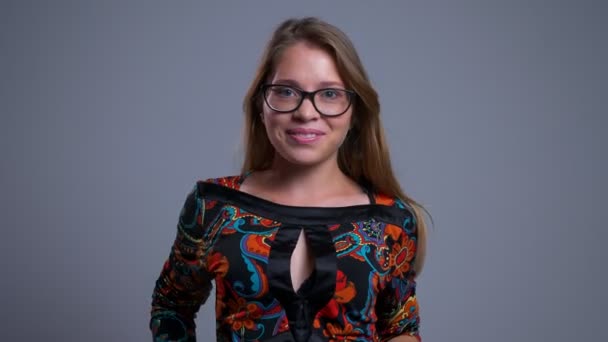 Primer plano retrato de joven mujer caucásica feliz en gafas sonriendo y mirando directamente a la cámara — Vídeos de Stock