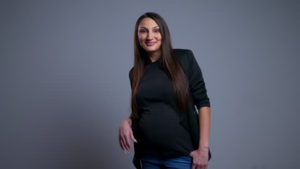 Nahaufnahme Porträt einer schwangeren jungen, fröhlichen Frau, die überrascht wird und mit der Hand winkt — Stockvideo