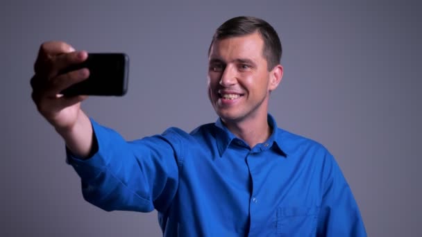 Closeup πορτρέτο του ελκυστική ευτυχισμένος άνθρωπος Καυκάσιος έχοντας μια κλήση βίντεο σχετικά με το τηλέφωνο — Αρχείο Βίντεο