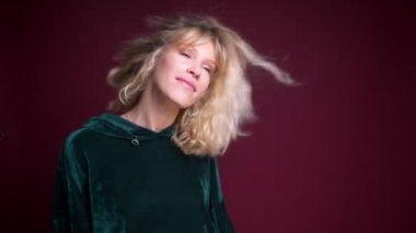 Portre sarışın saçları savurma ve neşeyle dans kamera önünde genç güzel beyaz kadın portresi.