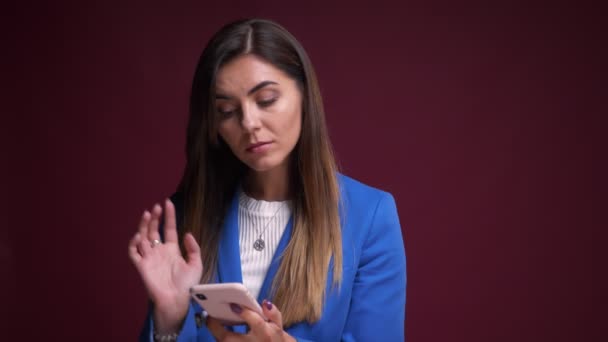 Retrato de close-up da moderna mulher caucasiana digitando no telefone e pensando na frente da câmera — Vídeo de Stock