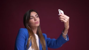 Telefonda selfies alarak ve kamera önünde gülümseyen çekici beyaz kadın portresi portre