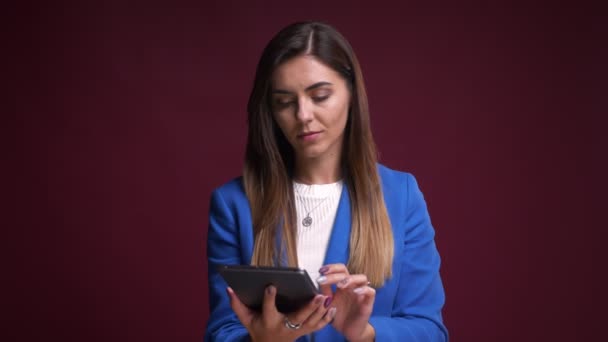 Gyönyörű fiatal kaukázusi nő segítségével a tabletta, és bemutatja a zöld képernyőn a kamera Vértes portréja — Stock videók