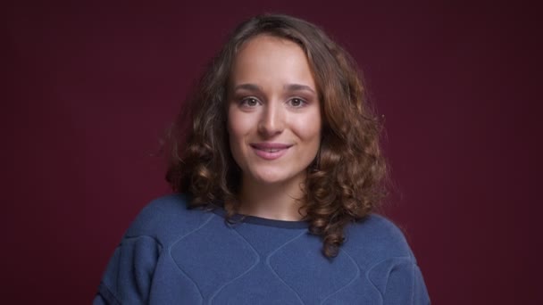 Detailní portrét mladé okouzlující Kavkazský žena s úsměvem a díval se přímo na kameru — Stock video