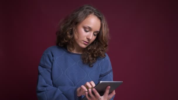 Retrato de primer plano de una joven mujer caucásica usando la tableta sonriendo y mostrando la pantalla verde a la cámara — Vídeo de stock