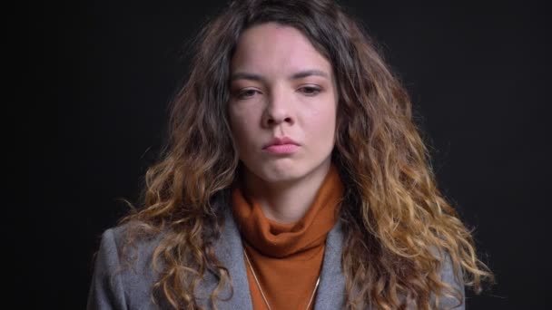 Nahaufnahme Porträt einer depressiven jungen kaukasischen Frau, die in die Kamera blickt und an den Seiten fast anfängt zu weinen — Stockvideo