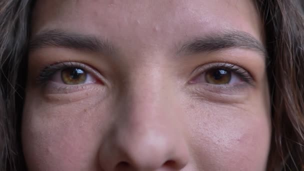 Macro close-up van mooie jonge vrouwelijke groene ogen kijken recht op de camera. — Stockvideo