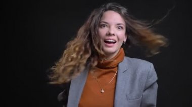 Portre portre çekici başarılı genç kadın saçları darmadağınık etrafında dönen ve getting sürpriz gülüyor