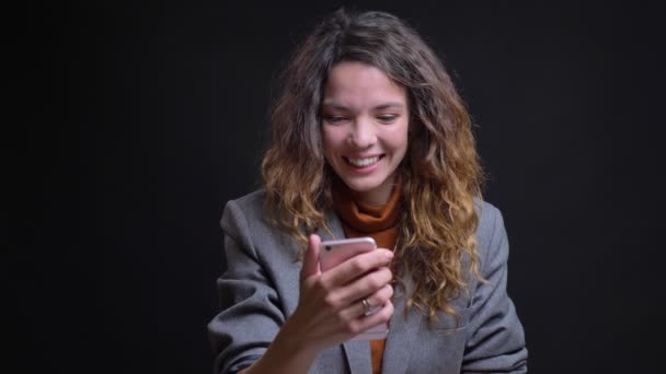 Closeup portret van mooie jonge vrouw met een video-oproep op de telefoon zwaaien van haar hand en het zeggen hello — Stockvideo