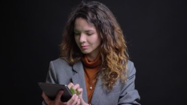 Esmer kadın dokunarak tablet ve kamera gülümseyen için onun perde gösteren çarpıcı portre portre