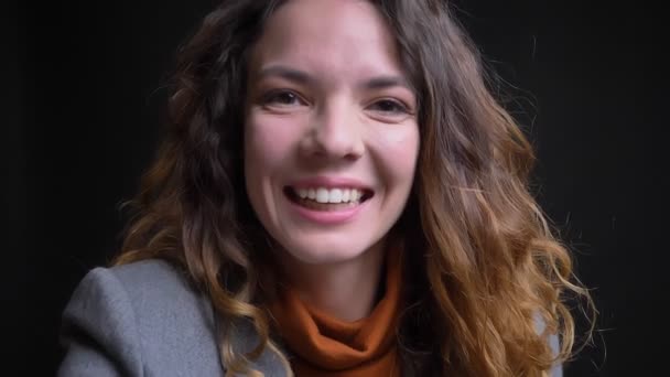 Nahaufnahme Porträt einer jungen brünetten Frau, die einen Videoanruf am Telefon hat, in die Kamera winkt und lächelt — Stockvideo