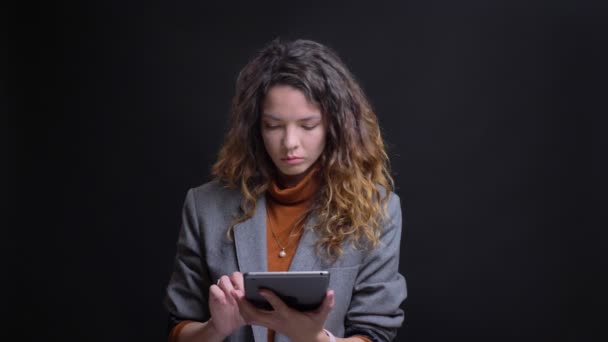 Closeup πορτρέτο του όμορφη επιχειρηματίας πληκτρολογώντας στο tablet και να thoughful — Αρχείο Βίντεο