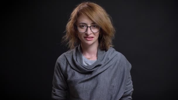Nahaufnahme Porträt attraktive erwachsene kaukasische Frau zwinkert lächelnd flirten und Blick in die Kamera mit dem Hintergrund isoliert auf schwarz — Stockvideo
