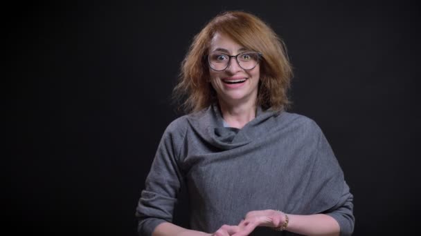 Närbild porträtt av glad kaukasiska medelålders kvinna känslomässigt reagerar på nyheter och glatt knyter hennes knytnävar — Stockvideo