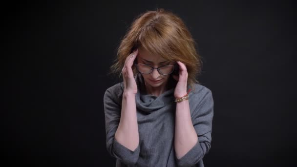 Portretul de aproape al unei femei îngrijorate și anxioase de vârstă mijlocie în ochelari devine nervos cu fundalul negru — Videoclip de stoc
