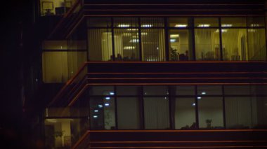 Ağır çekim shot insanların arkasında akşam şehir ofiste penceresinde çalışma.