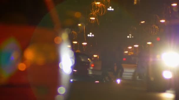 ゆっくりと歩行としっかりと夕方のカラフルな都市の車の移動のぼやけショット ライト背景 — ストック動画