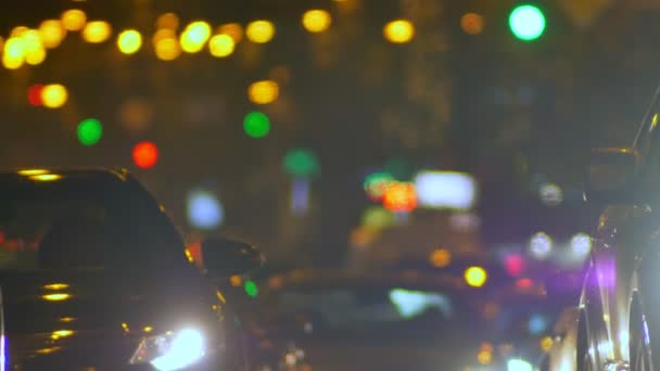 Rozmazaný záběr automobilů, pomalu se pohybující na noční výkupnu světla pozadí. — Stock video