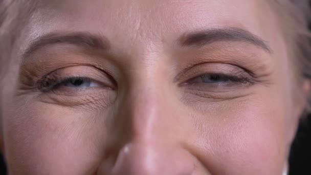 Closeup portrait of beautiful middle-aged female gray eyes looking at camera with smiling facial expression. — Stock Video