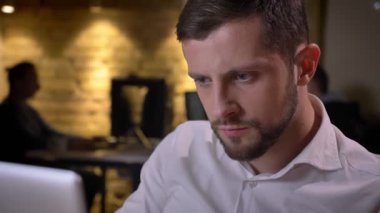 Dizüstü bilgisayarda yazarak ve ofiste kapalı kahve içme yetişkin beyaz işkadını closeup