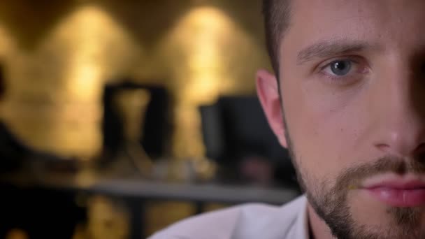 Gros plan portrait demi-visage de jeune caucasien visage masculin regardant droit à la caméra 