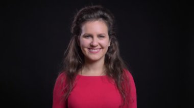 Siyah arka plan üzerine kamera içine sakince gülümseyerek kırmızı beyaz kadın portresi.