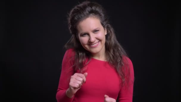 Porträtt av kaukasisk kvinna i röd flirtingly dansar in kameran på svart bakgrund. — Stockvideo