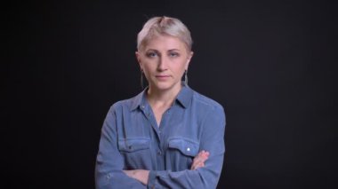Doğruca kameraya bakarak ve elleri olan orta yaşlı beyaz kadın portresi closeup geçti