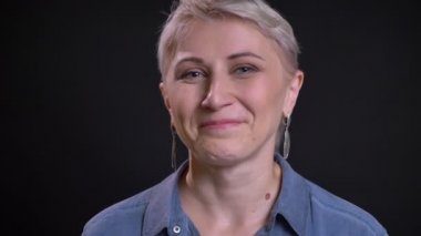 Mutlu Sarışın yetişkin beyaz kadın gülen ve kıkırdayan doğruca kameraya bakarak closeup portresi