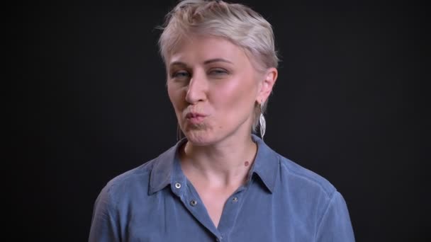 Closeup portret van flirten volwassen Kaukasische vrouwtje maken een kussen gelaatsuitdrukking en kijken recht op de camera — Stockvideo