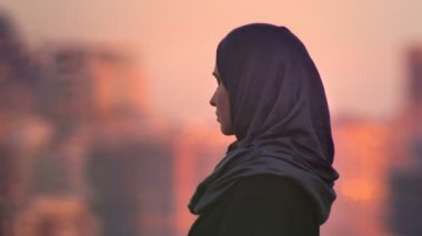 Portre portre genç çekici Müslüman kadın dört gözle ve bulanık akşam şehrin arkadaki kamerayla için dönüm