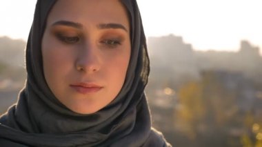 Doğruca kameraya günbatımı ile arka plan üzerinde seyir hijab genç çekici kadın portresi portre