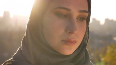 Genç çekici kadın türban düşünceli düz seyir ve kameraya parlayan güneş ile iki tarafta closeup portresi