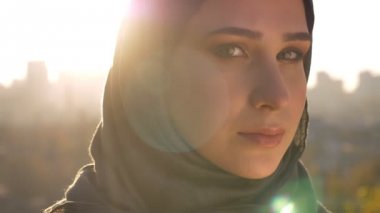 Kafa dönme ve kameraya şehrin arka plan üzerinde seyir hijab genç çekici kadın portresi portre