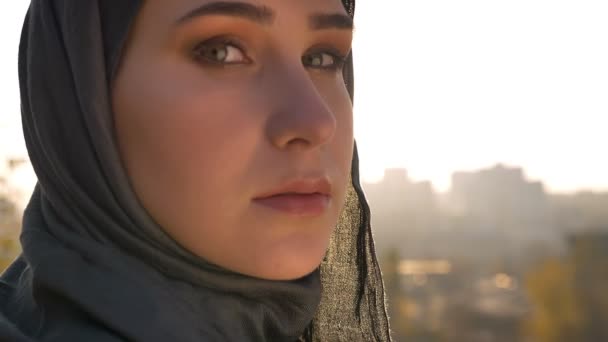 शहरी शहराकडे वळून कॅमेरा पाहून हिजबमध्ये तरुण आकर्षक महिलांचे मागे दृश्य बंद करा — स्टॉक व्हिडिओ