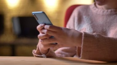 Yakın çekim portre profil kadın el smartphone ile office arka plan üzerinde çalışma.