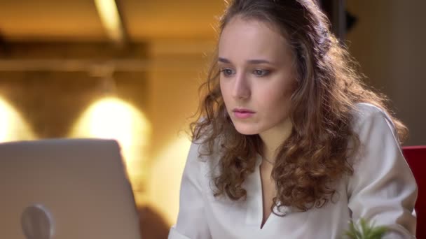 Close-up portret van curly-haired jongedame versteld op stoel in sterke frustratie en teleurstelling in kantoor. — Stockvideo