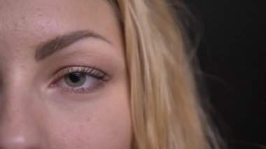 Yakın çekim yarı-portresi sakince kamera siyah arka plan üzerine içine izlerken Kafkas uzun saçlı kadın.