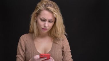 Smartphone ile siyah arka plan üzerinde şaşkınlık içine izlerken muhteşem beyaz uzun saçlı kadın portresi.