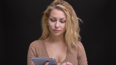 Muhteşem beyaz uzun saçlı kadın gülümseyerek içine kamera siyah zemin üzerine yeşil ekran tablet gösterilen portresi.