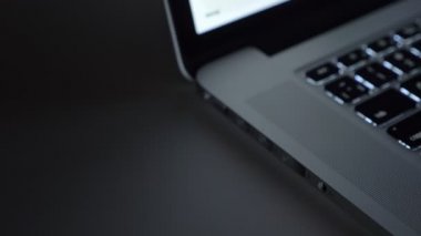 Yakın çekim shot erkek el hızla siyah tablo arka plan üstünde laptop içine usb kablo ekleme.