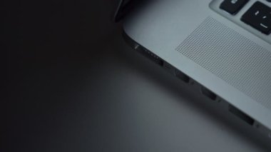 Erkek el hızla kordon laptop ve o ekleme yakın çekim çekim renkli siyah tablo arka plan üzerinde yanar